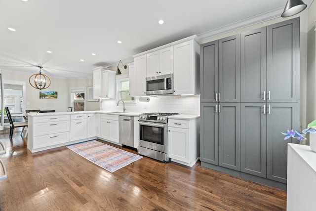 kitchen featuring gray cabinets, stainless steel appliances, decorative backsplash, hanging light fixtures, and white cabinets