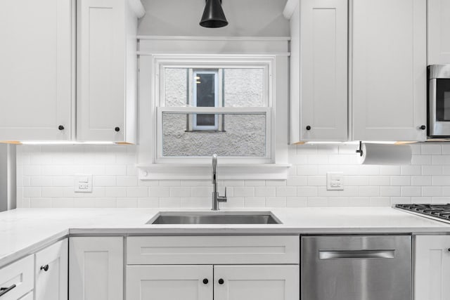 kitchen featuring white cabinets, appliances with stainless steel finishes, and sink