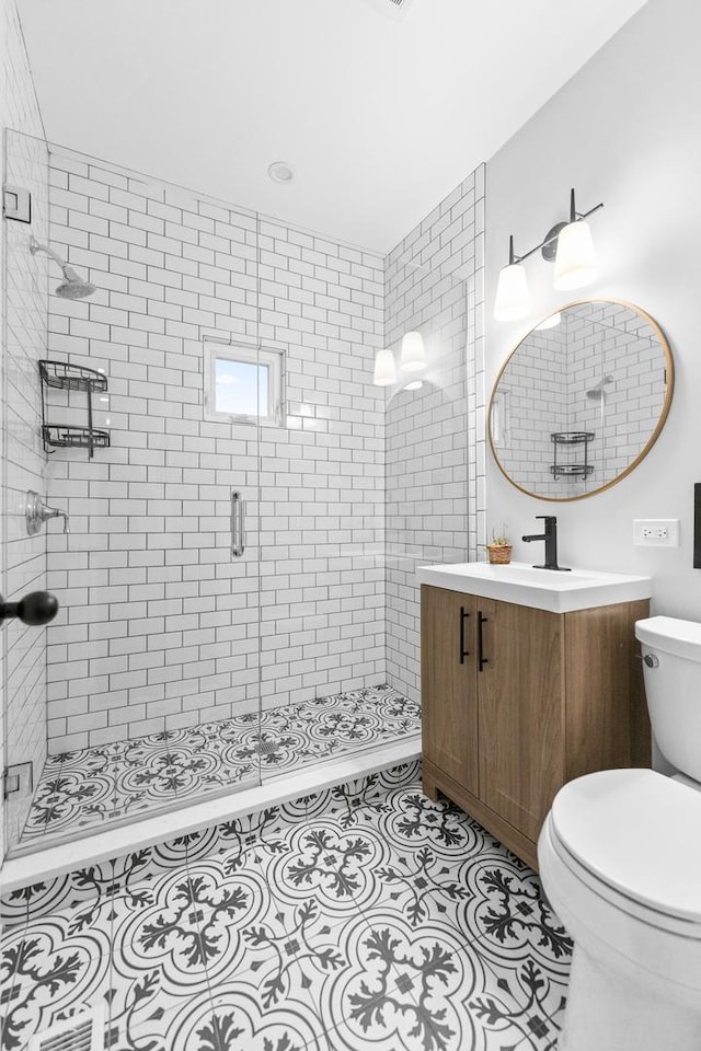 bathroom with toilet, vanity, tile patterned flooring, and an enclosed shower