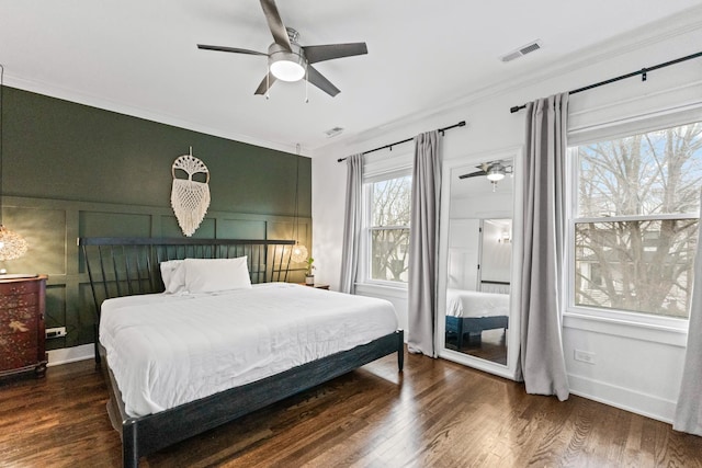 bedroom featuring ceiling fan, dark wood-type flooring, and ornamental molding