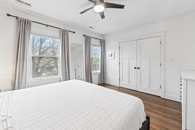 bedroom featuring ceiling fan, a closet, dark hardwood / wood-style flooring, and ornamental molding