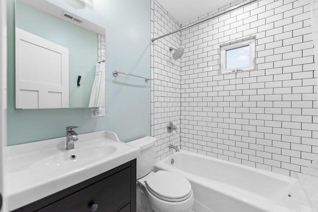 full bathroom featuring toilet, vanity, and tiled shower / bath