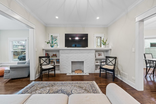 living room with dark wood-type flooring, ornamental molding, and plenty of natural light