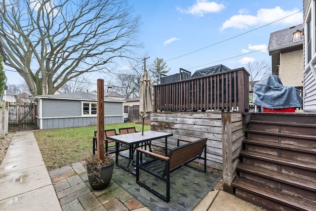 view of patio featuring an outbuilding and a deck