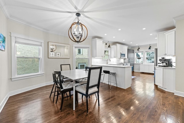 dining room featuring a large fireplace, ornamental molding, dark hardwood / wood-style flooring, and a notable chandelier