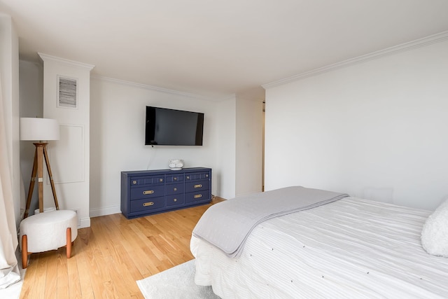 bedroom with light wood-type flooring and crown molding