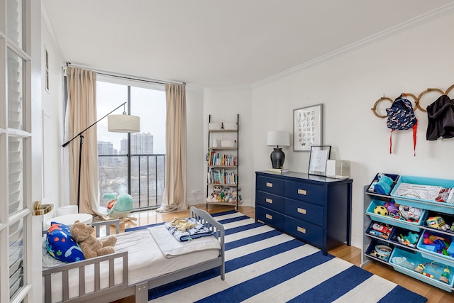 bedroom with crown molding and light hardwood / wood-style flooring