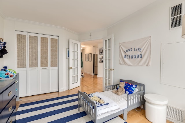 bedroom with crown molding, french doors, and hardwood / wood-style flooring