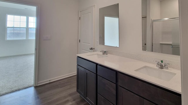 bathroom featuring vanity, wood-type flooring, and a shower with shower door