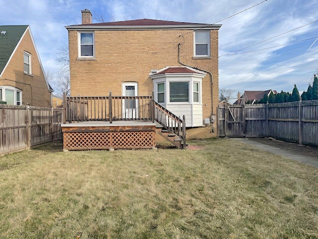 back of property featuring a wooden deck and a yard