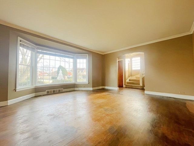 empty room with wood-type flooring and ornamental molding