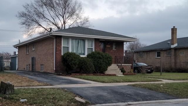 bungalow-style home with a front yard