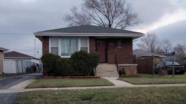 bungalow-style home with a front lawn