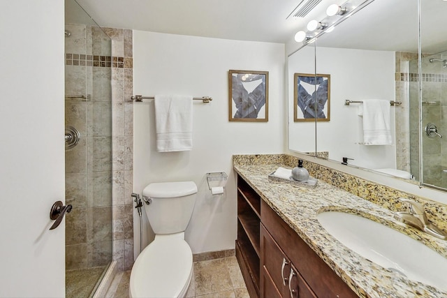 bathroom with toilet, vanity, and a shower with shower door