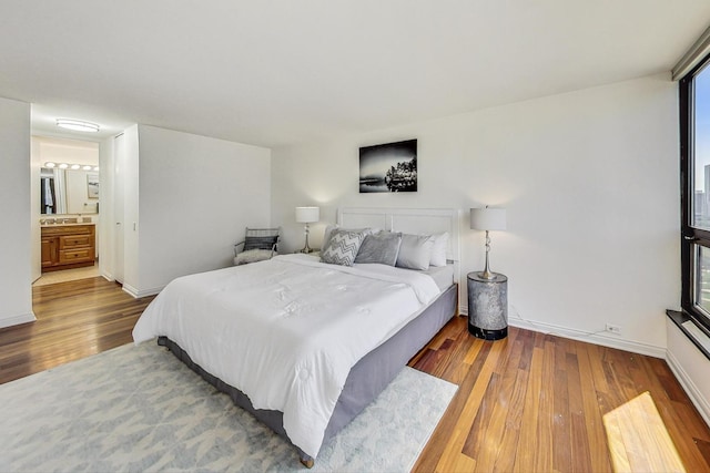 bedroom featuring wood-type flooring and connected bathroom