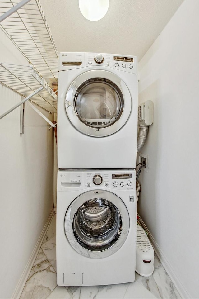 laundry room featuring stacked washer / drying machine