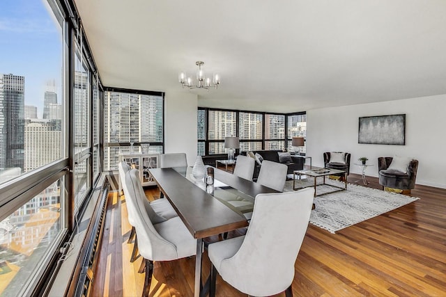 dining area featuring hardwood / wood-style flooring, a wealth of natural light, expansive windows, and a notable chandelier