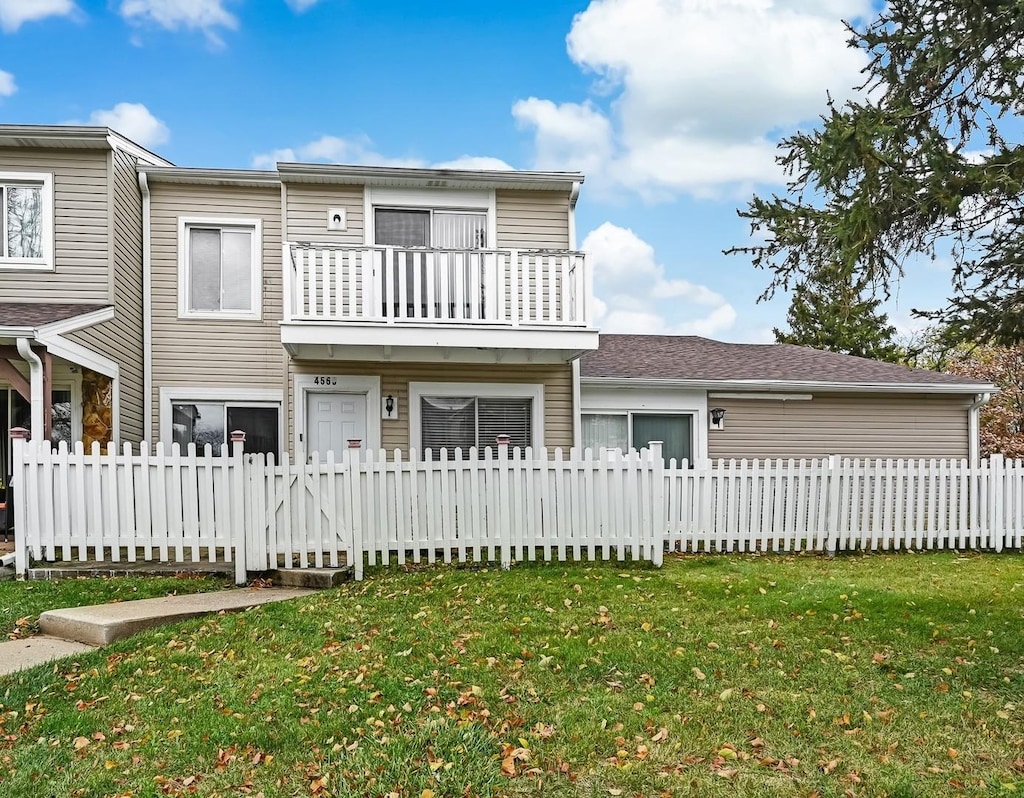 view of front of property featuring a balcony and a front lawn