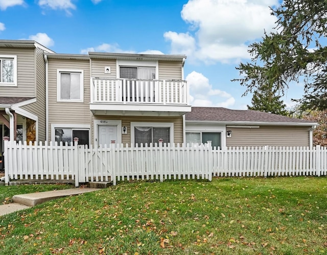 view of front of property featuring a balcony and a front lawn