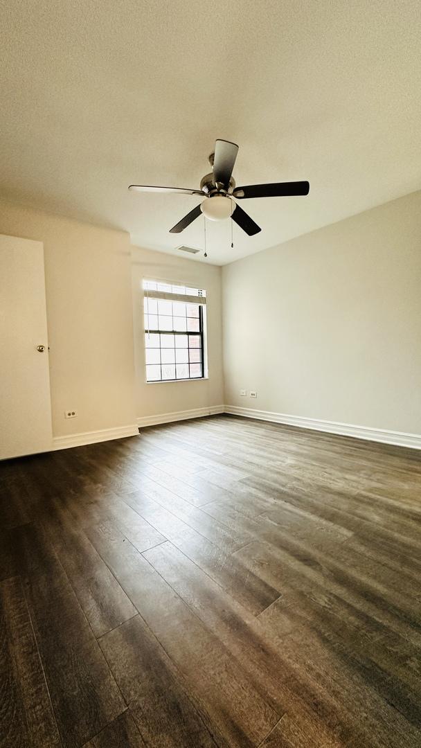 spare room with a textured ceiling, ceiling fan, and dark hardwood / wood-style floors