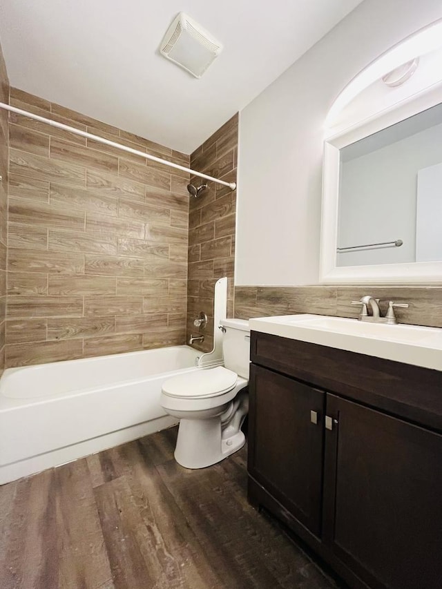 full bathroom featuring vanity, hardwood / wood-style flooring, toilet, and tiled shower / bath