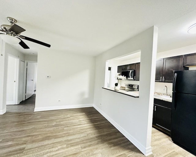 kitchen with ceiling fan, sink, light hardwood / wood-style floors, dark brown cabinets, and appliances with stainless steel finishes