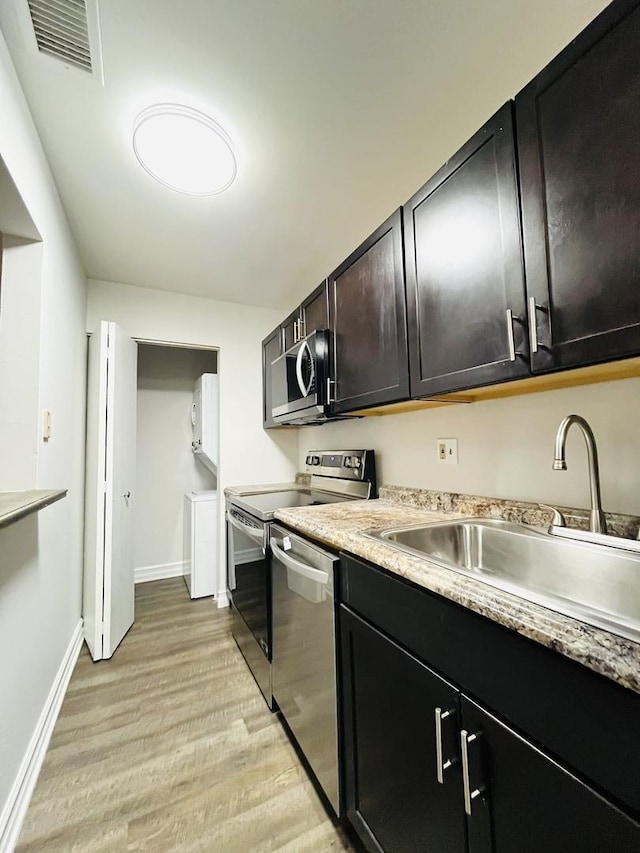 kitchen with light wood-type flooring, stainless steel appliances, and sink