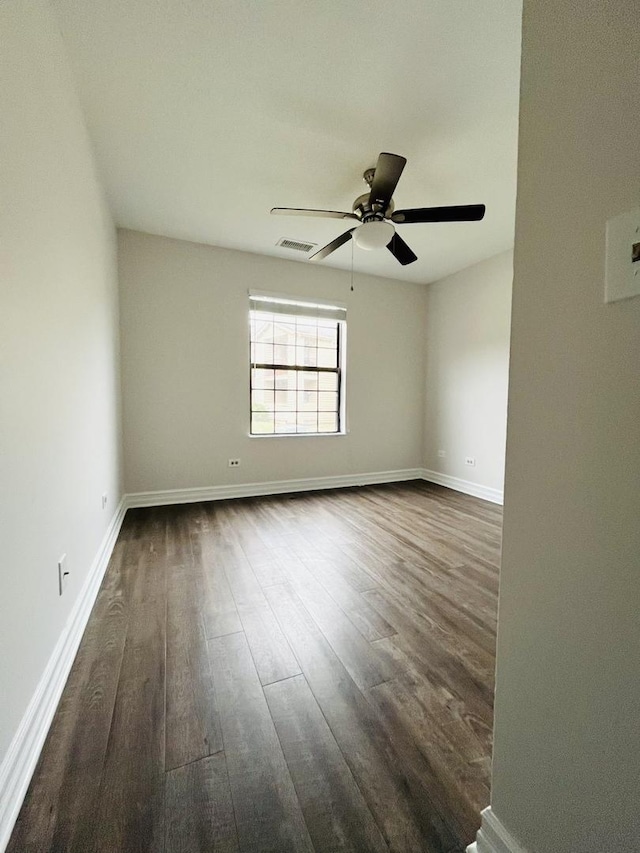 spare room featuring ceiling fan and dark wood-type flooring