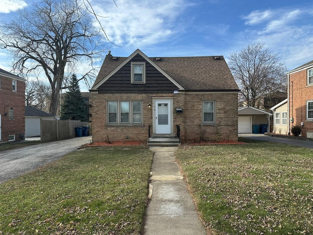 view of front of property with a garage, an outdoor structure, and a front lawn