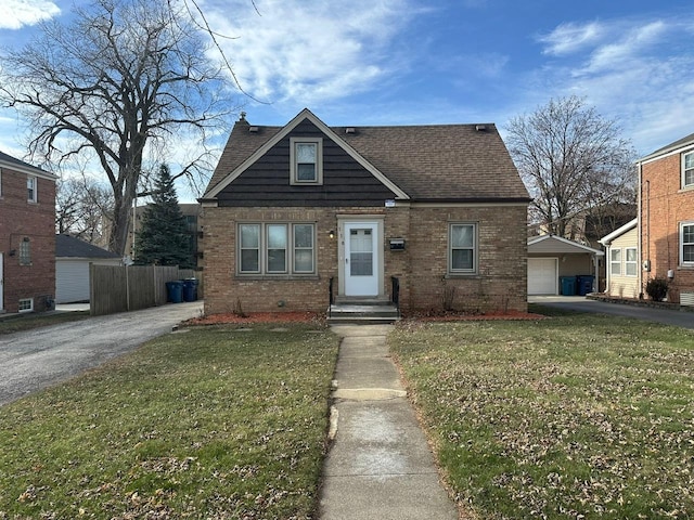 view of front of property with a garage, an outdoor structure, and a front lawn