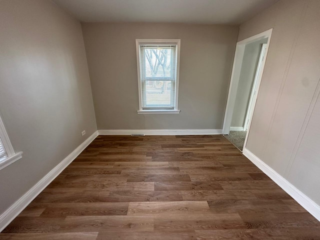 unfurnished room with dark wood-type flooring