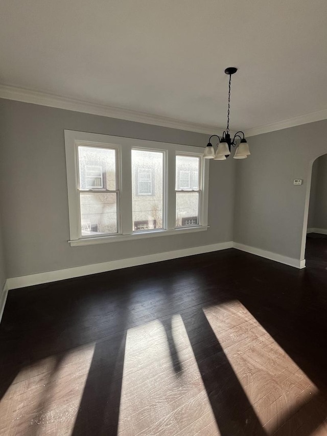 unfurnished dining area with dark hardwood / wood-style flooring, crown molding, and a chandelier