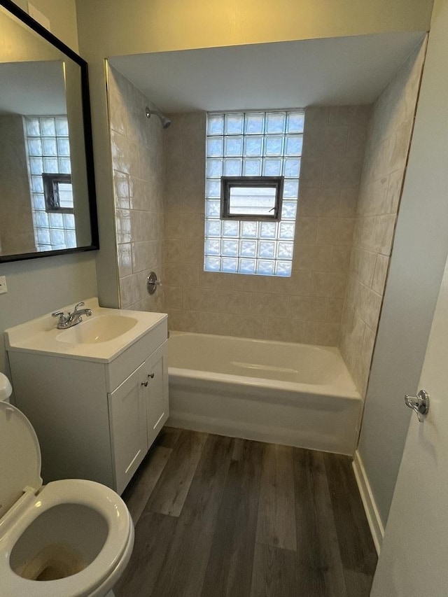 full bathroom featuring toilet, hardwood / wood-style floors, vanity, and tiled shower / bath