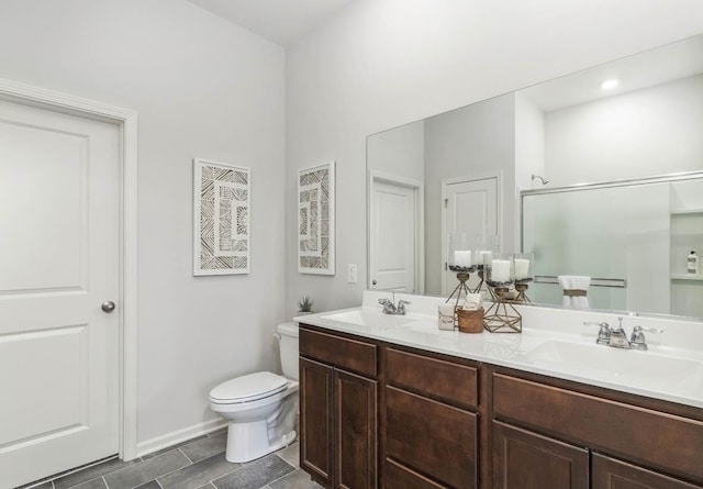 bathroom with vanity, toilet, and a shower with shower door