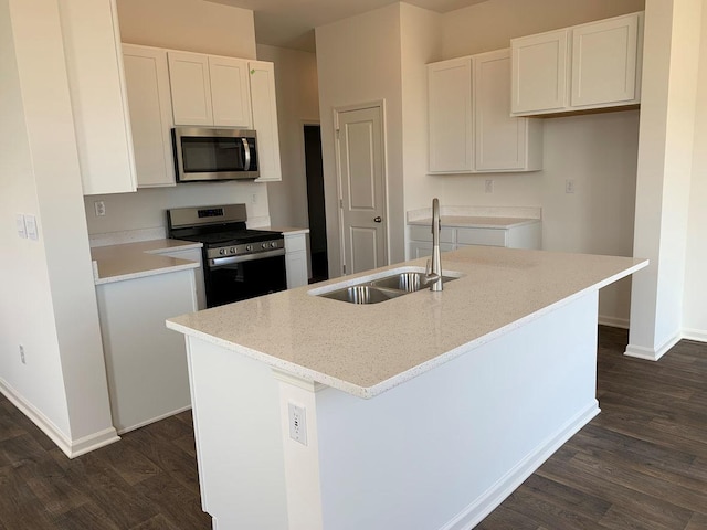 kitchen featuring a center island with sink, white cabinets, sink, dark hardwood / wood-style floors, and stainless steel appliances