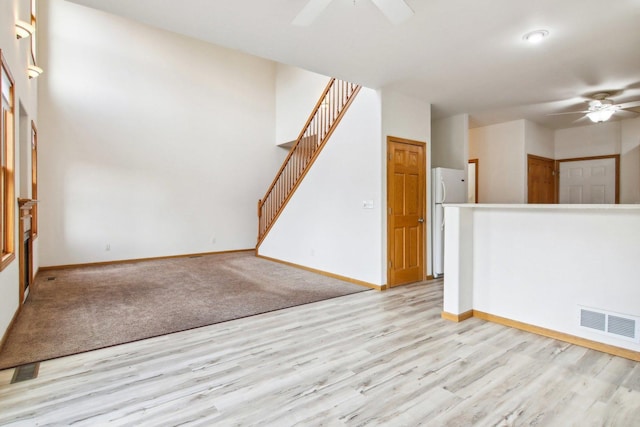 unfurnished living room featuring ceiling fan and light wood-type flooring