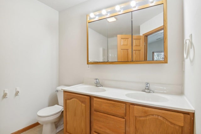 bathroom with tile patterned flooring, vanity, and toilet