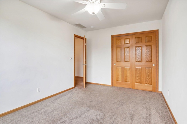 unfurnished bedroom featuring carpet flooring, ceiling fan, and a closet