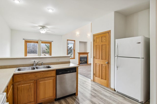 kitchen featuring sink, white refrigerator, stainless steel dishwasher, ceiling fan, and light hardwood / wood-style floors