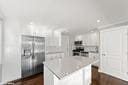 kitchen with white cabinetry and light stone counters