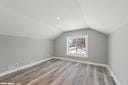 additional living space with hardwood / wood-style floors and lofted ceiling