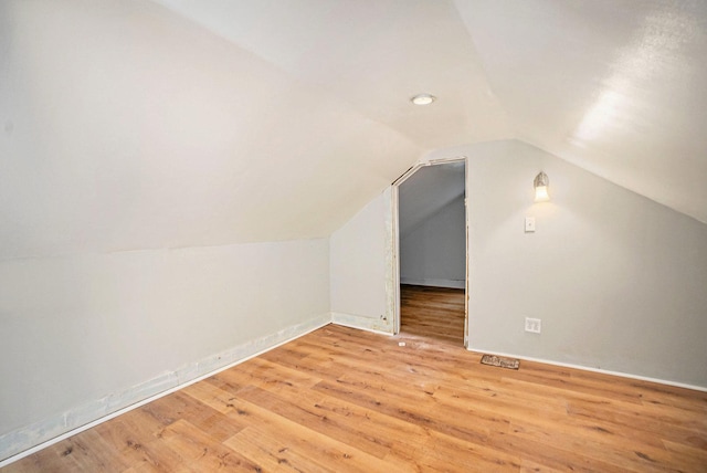 additional living space with wood-type flooring and lofted ceiling