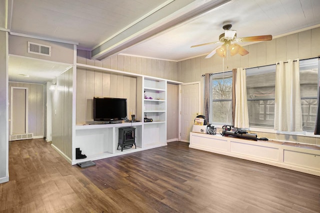 unfurnished living room with dark hardwood / wood-style flooring, ceiling fan, crown molding, and wood walls