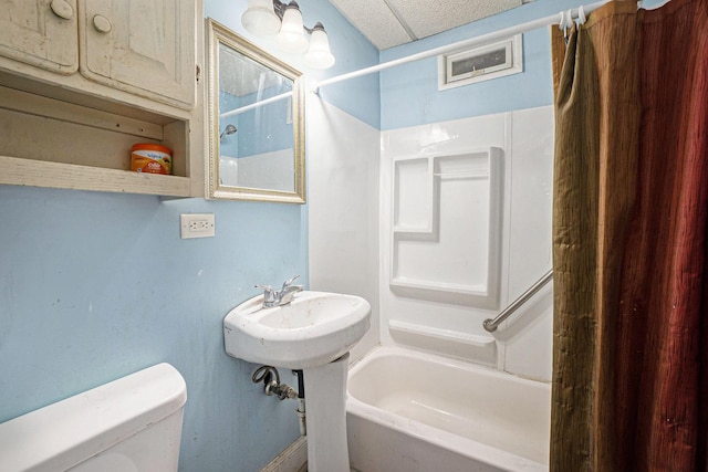 bathroom with toilet and shower / bath combo with shower curtain