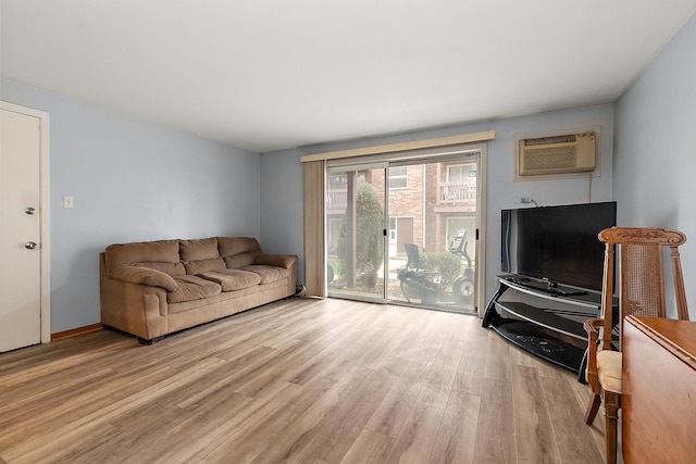 living room featuring an AC wall unit and light hardwood / wood-style flooring