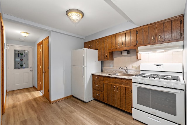 kitchen with decorative backsplash, light wood-type flooring, white appliances, and sink