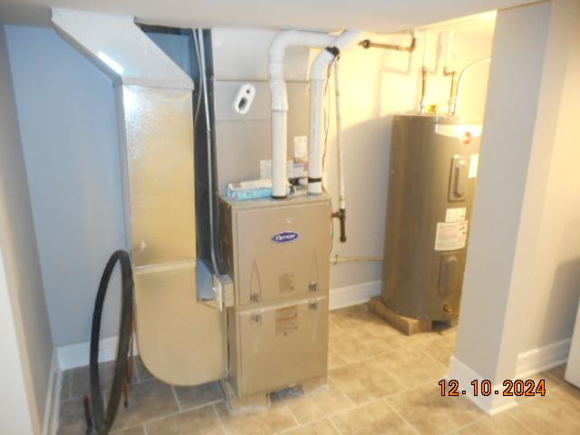 utility room featuring electric water heater and heating unit