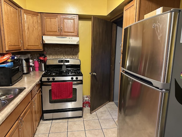 kitchen featuring tasteful backsplash, sink, light tile patterned floors, and stainless steel appliances