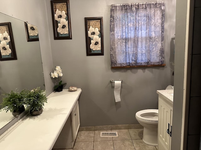 bathroom with tile patterned flooring, vanity, and toilet