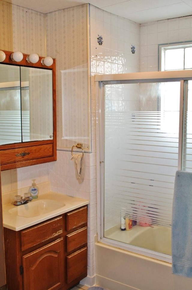 bathroom featuring vanity and bath / shower combo with glass door